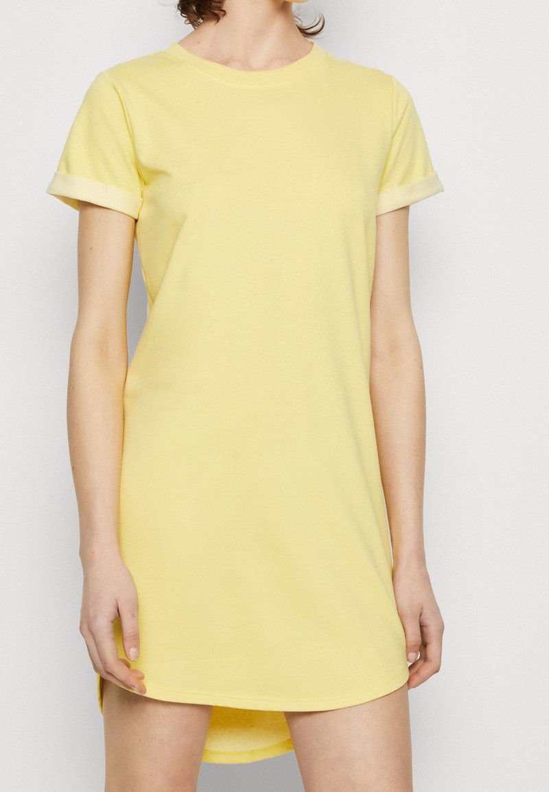 Robe t-shirt en coton jaune avec des manches courtes, un col rond et des finitions ourlées. Le tissu a une texture lisse et une coupe décontractée.