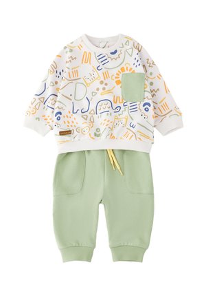 Completo per bambino con maglietta bianca a maniche lunghe con disegni colorati di animali e taschino verde sul petto, abbinato a pantaloni verde chiaro con tasche frontali.