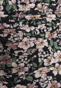 Tissu de robe à fleurs avec de grandes fleurs roses et blanches sur fond noir, agrémenté de feuilles vertes et d'accents blancs, disposés en plis.