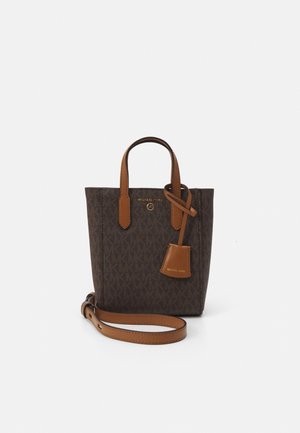 Sac cabas Michael Kors marron à motifs avec poignées beige et longue bandoulière réglable sur fond blanc.