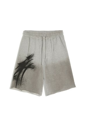 Shorts gris à taille élastique avec cordon de serrage et un motif abstrait en peinture aérosol noire sur la jambe gauche, avec des ourlets bruts.