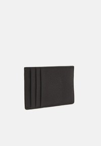 Porte-cartes en cuir noir avec finition texturée, comportant quatre fentes pour cartes et un design mince.