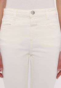 Witte denim jeans met een slim fit, voorzien van een knoopsluiting, een vijf-pocket ontwerp en subtiele stikdetails langs de naden.