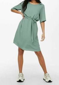 Grünes knielanges Kleid mit kurzen Ärmeln und einem abnehmbaren Gürtel in der Taille; aus glattem Stoff mit lässiger Passform.