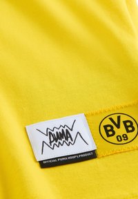 Gul sportstrøje med tekstureret stof. Har hvid og sort Puma-logo og en gul lap med teksten "BVB 09."