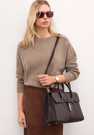 Borsa a spalla in pelle marrone scuro con design strutturato, hardware argentato e doppi manici. La texture appare granulosa e la base è dotata di piedini protettivi.