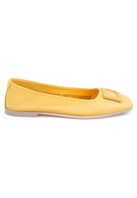 Gelbe Leder-Ballettschuhe mit quadratischer Zehenpartie, auffälliger dekorativer Schnalle auf der Zehe und einer hellen, flachen Sohle. Glatte Textur.