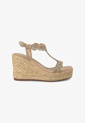 Sandalia de cuña beige con suela de yute trenzado, diseño de tira en T y acentos circulares de rhinestone. Parte superior de textura suave y correa de tobillo ajustable.