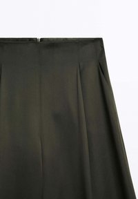 Dół w ciemnooliwkowym kolorze, o gładkiej fakturze, z plisami i zapięciem na zamek z tyłu, co nadaje mu dostosowany, elegancki wygląd.
