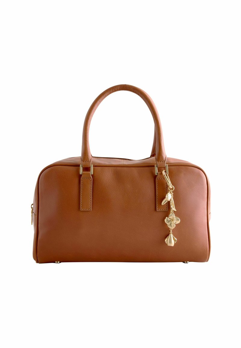 Sac à main en cuir marron avec une forme structurée, doté de deux poignées courtes et d'un charm décoratif en or sur la fermeture éclair.