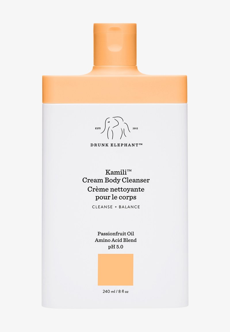 Drunk Elephant Kamili Cream Body Cleanser, 240 ml, zeichnet sich durch eine weiße Flasche mit einem orangefarbenen Deckel aus, die mit Produktdetails und einem minimalistischen Elefantenlogo beschriftet ist.