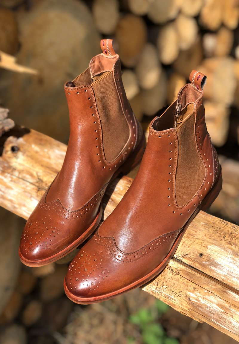 Bottines Chelsea en cuir marron avec des panneaux latéraux élastiques, des détails en brogue sur le bout et une texture contrastante. Talon empilé et boucle de tirage inclus.