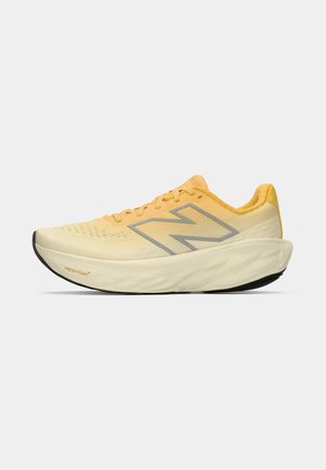 Scarpa da corsa gialla e crema con suola spessa e ammortizzata, grande logo "N" e suola nera, vista dal lato esterno.