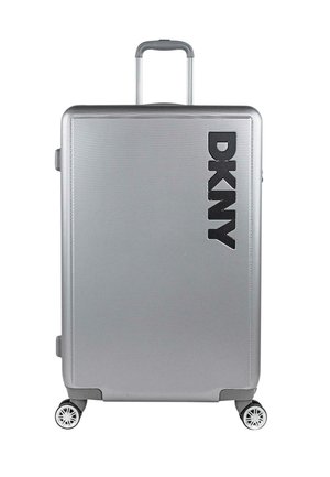 Maleta rígida plateada con superficie texturizada, que presenta un prominente logo negro de DKNY, un asa retráctil y cuatro ruedas multidireccionales.
