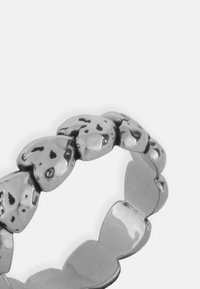 Srebrna prsten u obliku srca sa poliranim završetkom, koji ima teksturirani dizajn i izmjenjive glatke i udubljene površine.