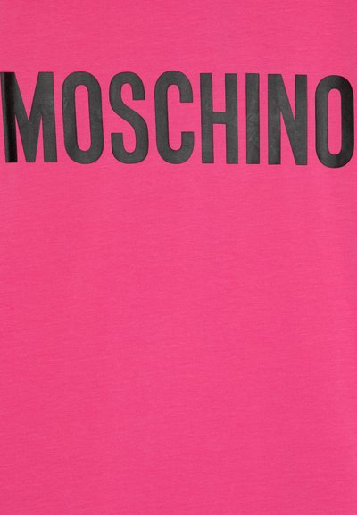 Rožinė medvilninė marškinė, išsiskirianti ryškiu juodu „MOSCHINO“ užrašu priekyje, su lygiu, tekstūruotu audinio paviršiumi.