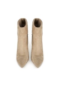 Botas de tobillo de ante beige con diseño de punta afilada, que cuentan con un puño doblado y detalle de cremallera lateral. Textura suave y silueta elegante.