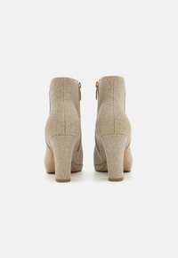 Beżowe botki na obcasie za kostkę z teksturowanym materiałem, zamek błyskawiczny z boku i solidny obcas. Gładka podeszwa i zaokrąglony czubek.