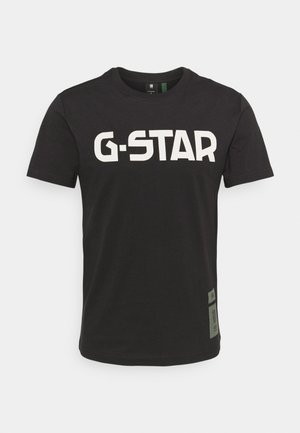 Schwarzes T-Shirt mit kurzem Arm und Rundhalsausschnitt, vorne großflächig mit weißem "G-STAR"-Schriftzug bedruckt, mit kleinem Label auf der unteren linken Seite.