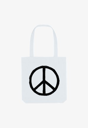 Witte tote bag met twee schouderbanden, met een groot zwart vredessymbool op de voorkant gedrukt. De stof lijkt stevig en duurzaam.