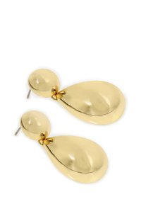Boucles d'oreilles dorées présentant un clou rond avec une forme en goutte d'eau. Surface lisse et brillante avec un délicat accent en nœud à l'attache.