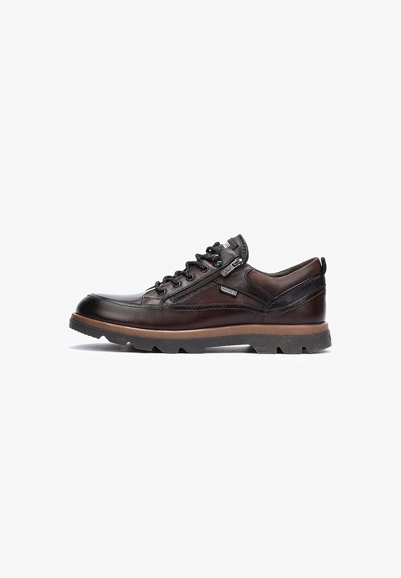 Souliers en cuir marron avec un bout arrondi, des côtés texturés et des lacets noirs. Dotés d'une semelle rembourrée et d'un branding discret sur le côté.