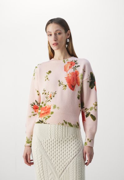 Knitted sweater in soft pink with oversized floral patterns in orange and green. Features a ribbed neckline and cuffs, cropped design.
