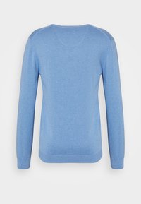 Jasnoniebieski sweter z długim rękawem z okrągłym dekoltem i prążkowanymi mankietami. Wykonany z miękkiej tkaniny, o gładkiej fakturze i dopasowanym kroju.