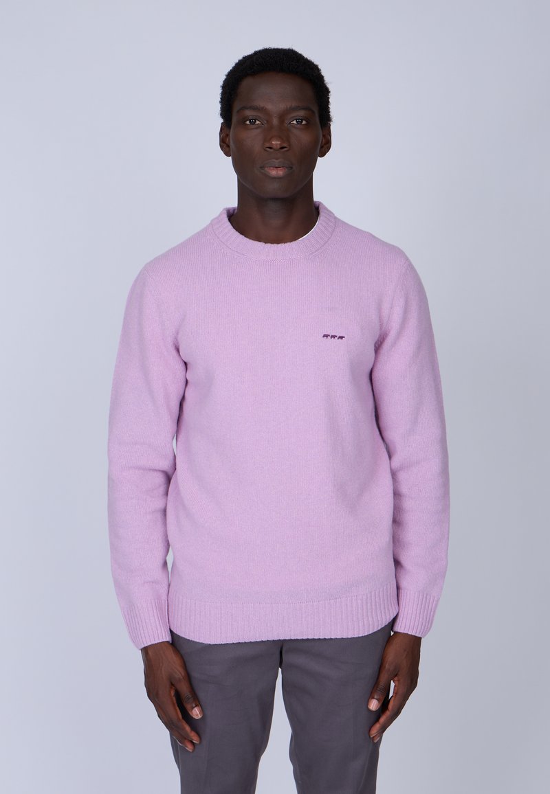 Pull en tricot rose clair avec un col rond classique et des poignets côtelés, présentant un petit logo brodé sur la poitrine.