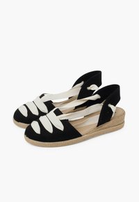 Černé plátěné espadrilky s bílými elastickými pásky, otevřenou patou a solí podobnou jutě, s křížovým designem a texturovaným svrškem.