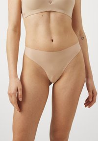 Nude bielizna w stylu bikini z gładkiego, elastycznego materiału. Posiada bezszwowy krój i niski stan dla minimalnego przykrycia.