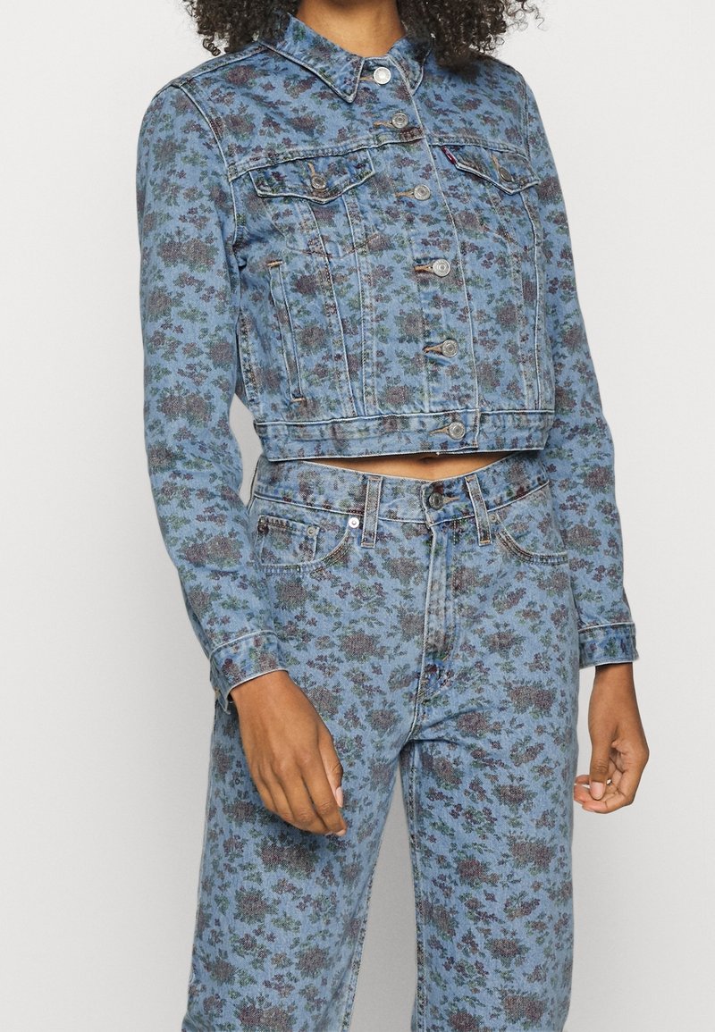 Denimjakke med blomstermønster i nuancer af blå og lilla, med en cropped design, krave og frontknaplukning.
