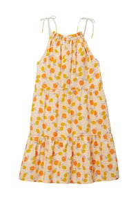 Robe d'été à volants en tissu blanc ornée de motifs de fruits orange et jaune et de feuilles vertes. Elle présente des bretelles réglables et un ourlet froncé.