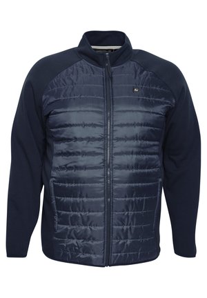 Veste zippée marine avec un devant rembourré et des manches en tissu lisse. Présente un col haut et des poches latérales, rehaussée d'un logo.