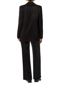 Black blazer and pants ensemble, featuring smooth, shiny texture, tailored design, long sleeves, and a single button detail at the back.