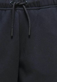 Marinefarbene Jogginghosen aus weichem Baumwollmix, mit einem Kordelzugbund und schwarzen Kunststoffenden sowie einem glatten, strukturierten Stoff.