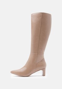 Botas de cuero beige hasta la rodilla con punta afilada y tacón transparente en bloque. Textura suave y detalle de costura mínima en la parte superior.