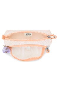 Borsetta Kipling con zip di colore pesco chiaro e motivo geometrico, dotata di una morbida fodera interna e un charm a forma di scimmia viola attaccato.