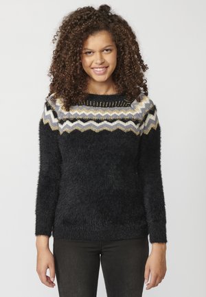 Un pull noir en peluche avec un motif zigzag multicolore en gris, or et blanc au niveau de l'encolure. Manches longues, tissu texturé.