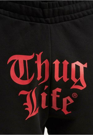 Black sweatpants featuring large red text that reads "Thug Life" in a bold, stylized font on the back. Soft fabric with elastic waistband.