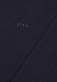 Granatowa tkanina o fakturowanej powierzchni z delikatnym połyskiem; logo „P.L” w ciemniejszym odcieniu wtopione w materiał.