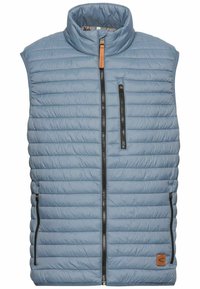 Light blue insulated vest with quilted design, high collar, two zippered pockets, and a small brown logo patch on the bottom left.