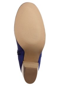 Modré semišové boty s texturovanou podrážkou, nízkým podpatkem a hladkým hnědým základním dílem, který má žebrovaný design pro lepší přilnavost.