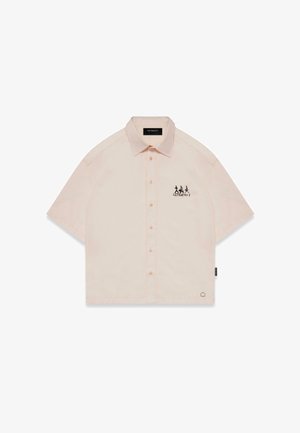 Košeľa s krátkym rukávom v broskyňovej farbe, s výstrihom s klopami, predným zapínaním na gombíky a čiernym grafickým dizajnom na ľavej hrudi.