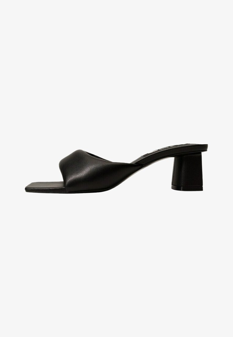 Mules ouverts en cuir noir avec un dessus texturé et un bout carré. Présente un épais talon bloc pour plus de stabilité. Design minimaliste dans l'ensemble.