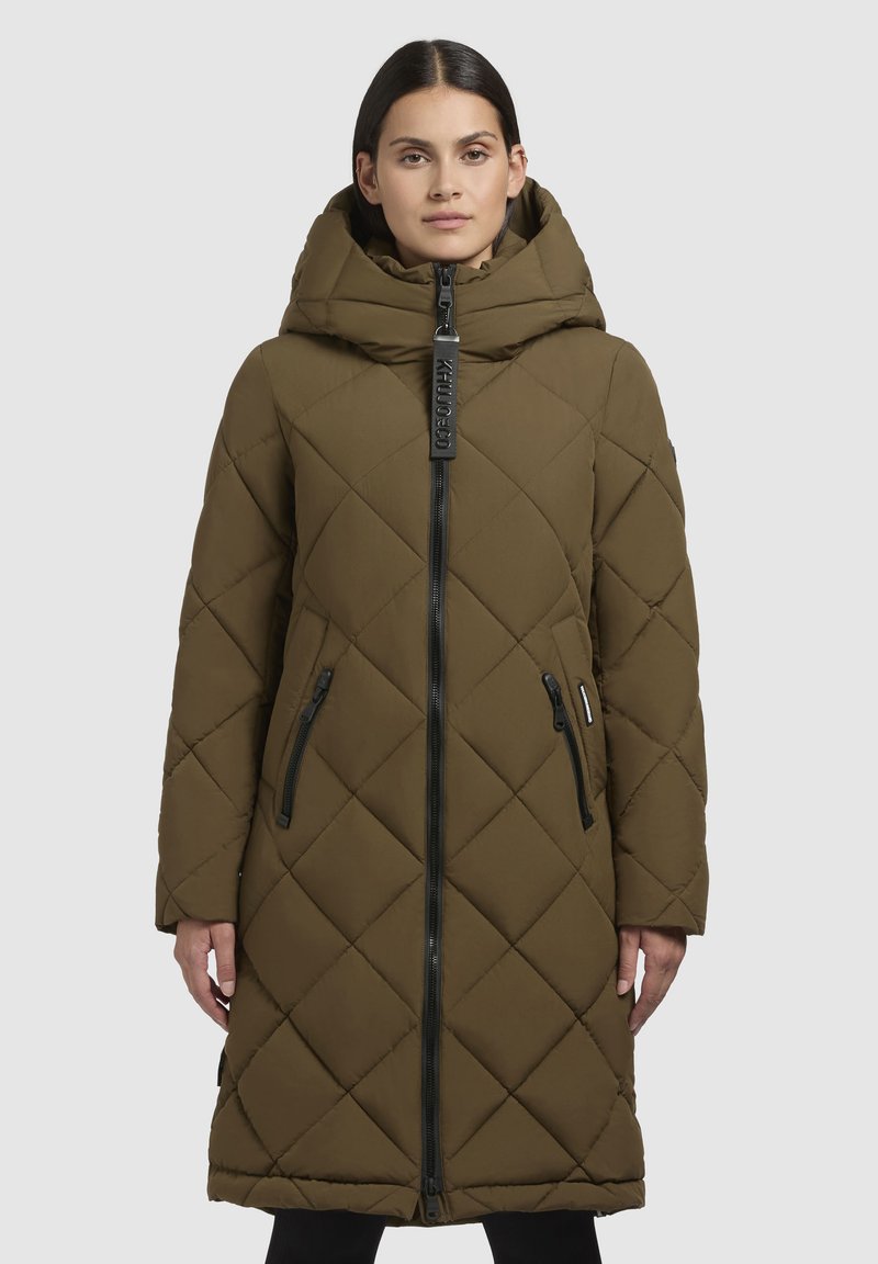 Parka căptușită de culoare măslinie cu un model cu diamante, fermoar frontal, glugă mare și două buzunare laterale cu fermoar, având accente de hardware negre.