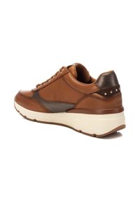 Zapatilla de cuero marrón con acentos grises, puntera redonda, entresuela beige, ojales dorados y pequeñas tachuelas decorativas en el talón.