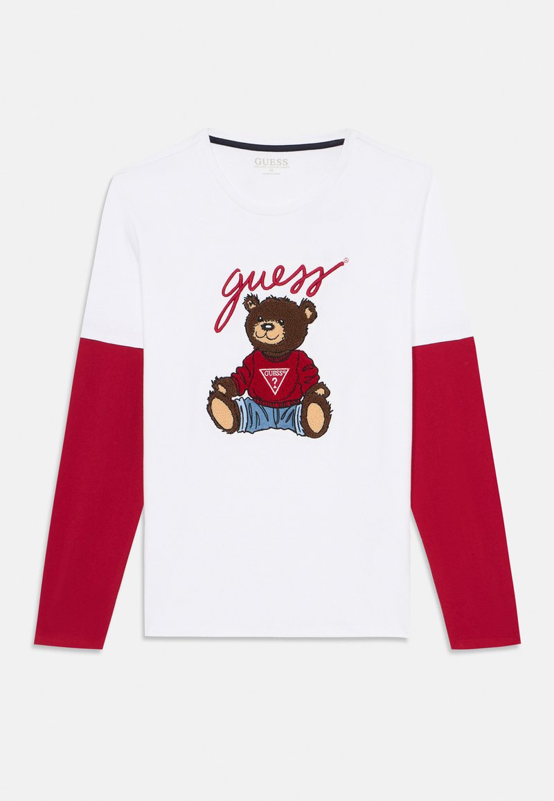 Weißes Langarmshirt mit einem Design eines braunen Bären, der einen roten Pullover und blaue Jeans trägt, mit roten Ärmeln und dem Text 'guess' darüber.