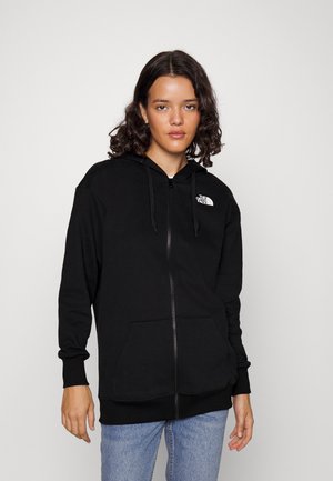 Sudadera con cremallera negra, hecha de un tejido suave, con un bolsillo tipo canguro, puños acanalados y el logo de The North Face en el lado izquierdo del pecho.