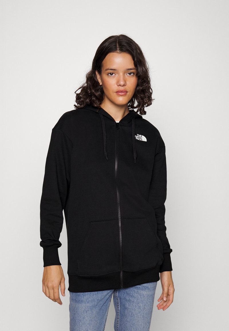 Sudadera con cremallera negra, hecha de un tejido suave, con un bolsillo tipo canguro, puños acanalados y el logo de The North Face en el lado izquierdo del pecho.